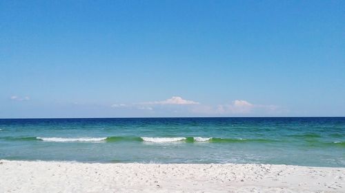 Scenic view of beach against clear blue sky