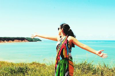 Woman standing at beach against clear sky