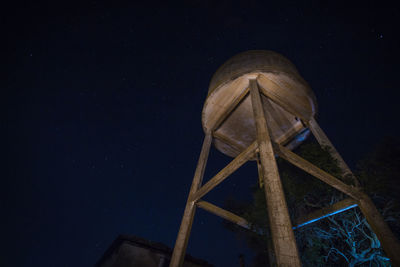 Low angle view of old water tower against sky at night