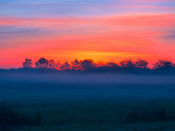 Scenic view of field against sky during sunset