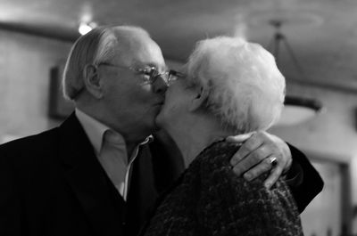 Close-up of senior couple kissing at home