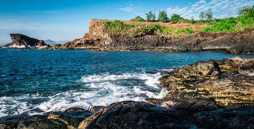 Scenic view of rocks in sea against sky