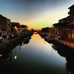 Reflection of buildings in water at sunset