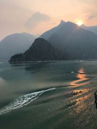 Scenic view of sea and mountains against sky during sunset