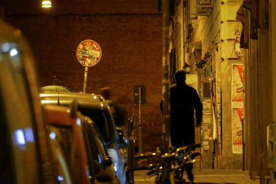 Rear view of man on illuminated car at night