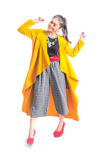 Portrait of young woman standing against white background