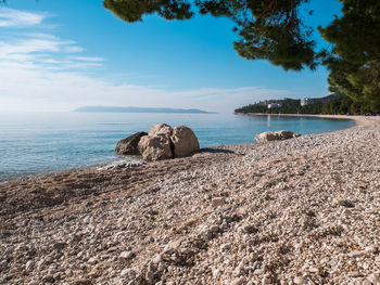 Scenic view of rocks on beach against sky