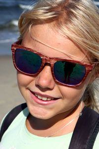 Close-up portrait of smiling girl at beach