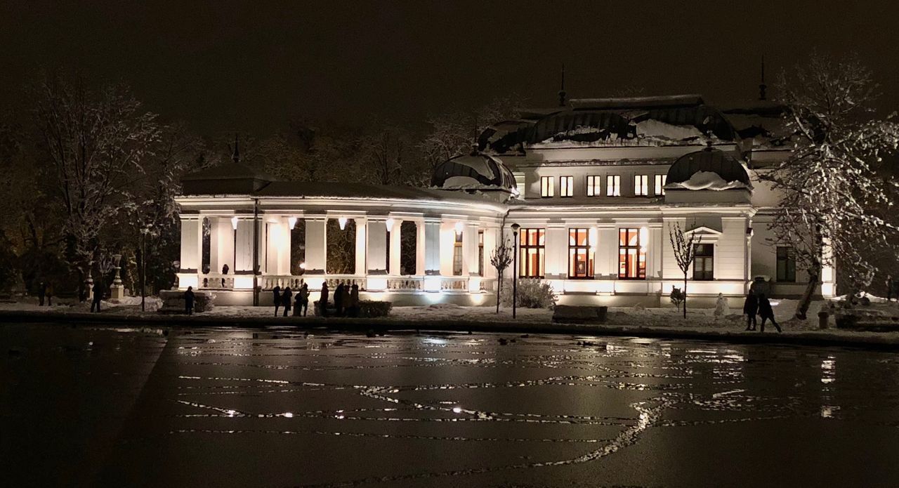 BUILDING BY ILLUMINATED STREET AT NIGHT