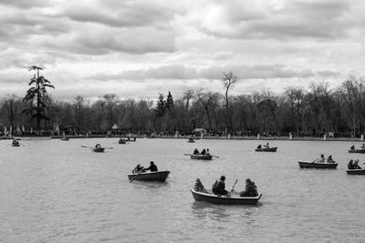 Boats in sea against cloudy sky