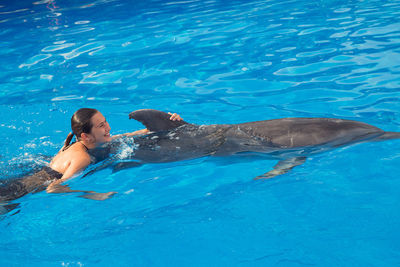 Full length of shirtless man swimming in pool