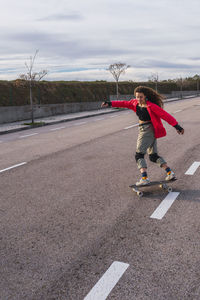 Woman skating with skateboard on road