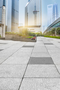 View of city street and modern buildings against sky