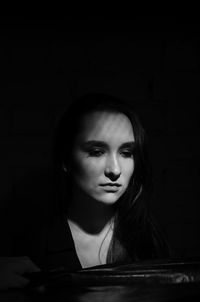 Close-up of thoughtful woman looking away in darkroom