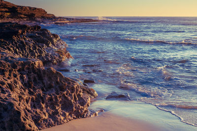 Scenic view of beach against sky during sunset