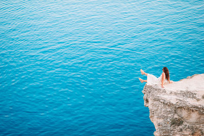 High angle view of woman on rock by sea