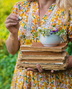 Midsection of woman holding potted plant