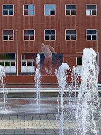 Fountain by building in city