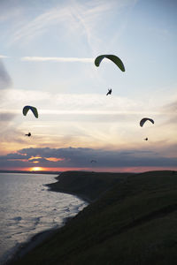 Paragliders at sunset
