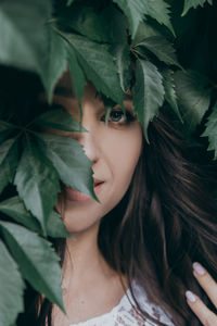 Close-up portrait of a young woman with leaves