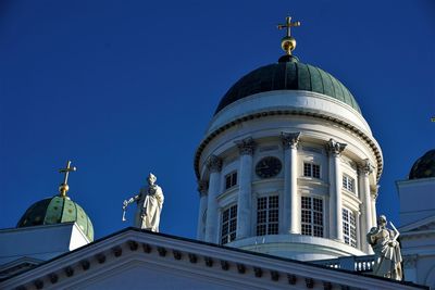 Low angle view of statue of building against clear blue sky