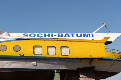 Low angle view of information sign against clear blue sky