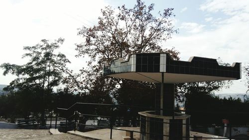 Built structure by trees in park against sky