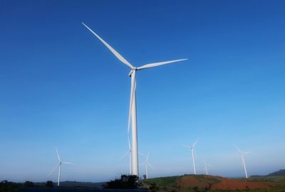 Low angle view of windmill against clear blue sky