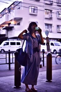 Full length of woman standing on street in city