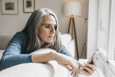 Woman sitting on the couch looking at cell phone