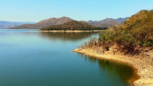 Scenic view of lake and mountains against clear sky