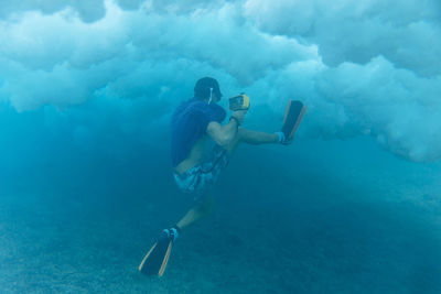 Man holding camera while swimming undersea