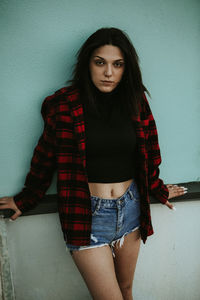 Portrait of beautiful woman standing against wall