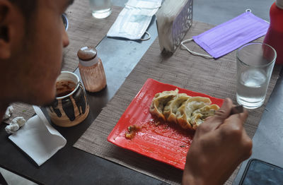 Cropped image of man eating momos