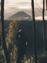 Man photographing on mountain against sky