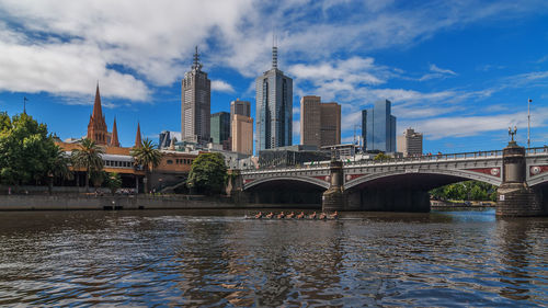 Bridge over river against buildings in city