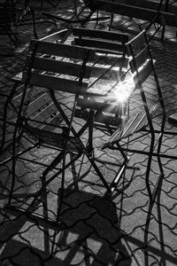 High angle view of metal chair on sunny day