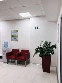 Empty chairs and table against wall in building