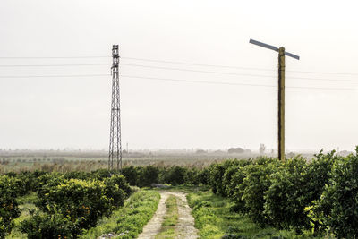 Electricity pylon on field against sky