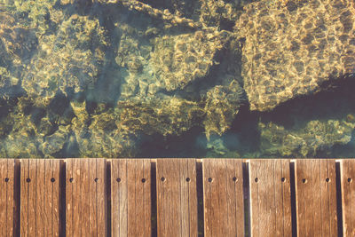 Directly above shot of pier over rocks in sea