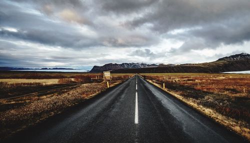 Road amidst landscape against dramatic sky
