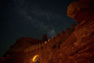 Low angle view of rock formation against sky at night