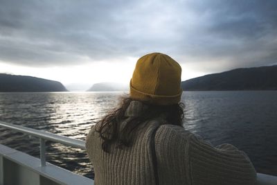 Rear view of woman looking at sea against sky