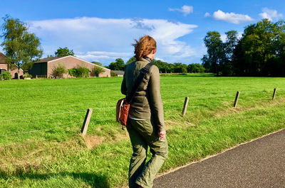 Rear view of woman standing on field