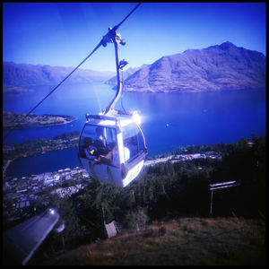 Overhead cable car on mountains against sky