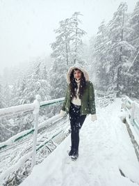 Woman standing on snow covered tree