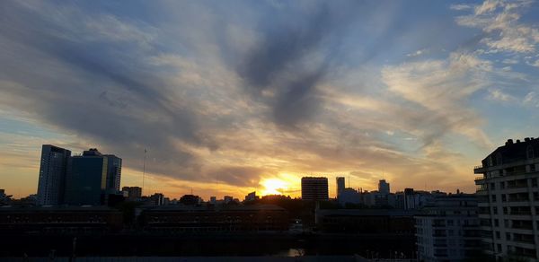 Buildings in city against sky during sunset