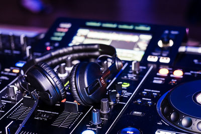 Close-up of headphones on sound mixer at nightclub