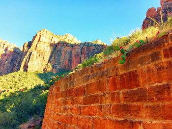 Low angle view of rocks against clear blue sky