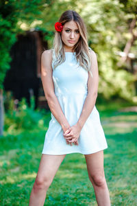 Full length of a beautiful young woman standing on field